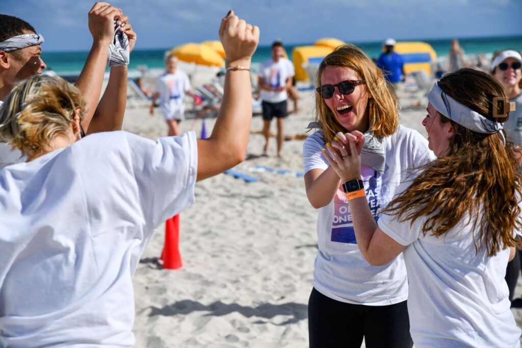 corporate event planner Miami team building beach activity with employees collaborating