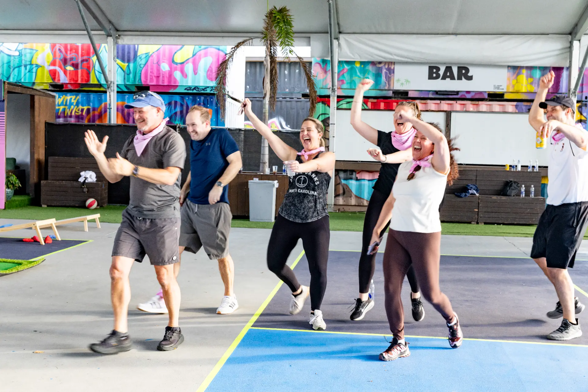 corporate event planner Miami team building activity with group participants celebrating and engaging in outdoor event