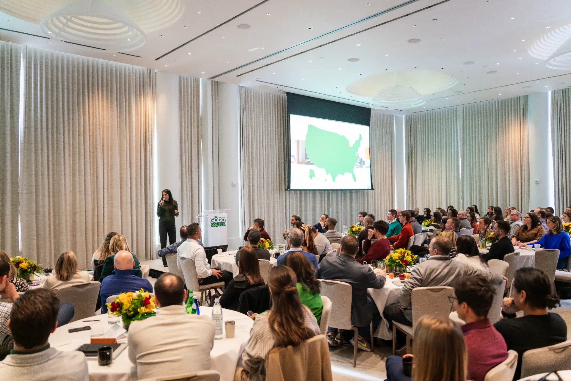 corporate event planner Miami conference event with speaker presentation and audience in meeting room